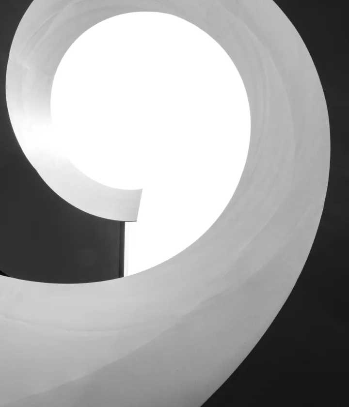 Spiral staircase curling around a bright skylight