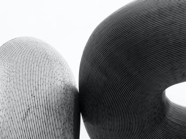 Two ribbed sculptural volumes leaning against each other
