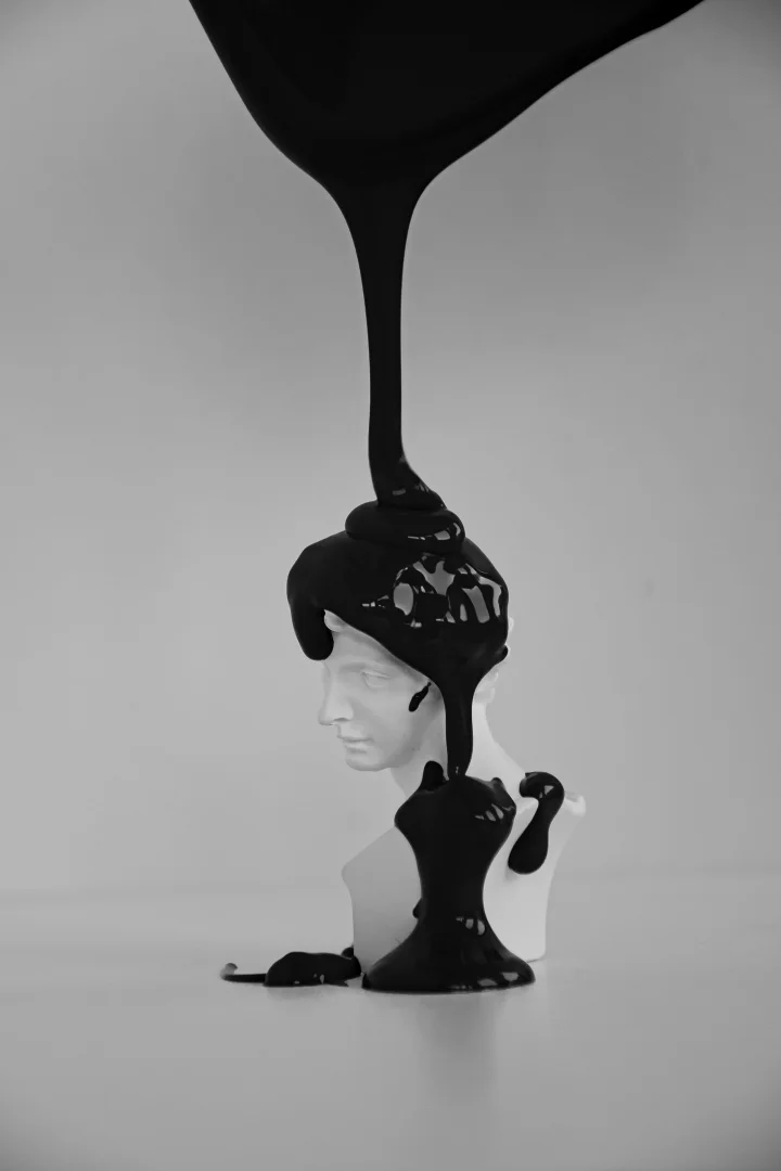 Black paint pouring over a classical plaster bust