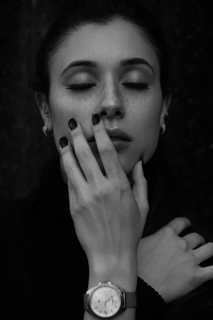 Portrait of a woman with closed eyes touching her face